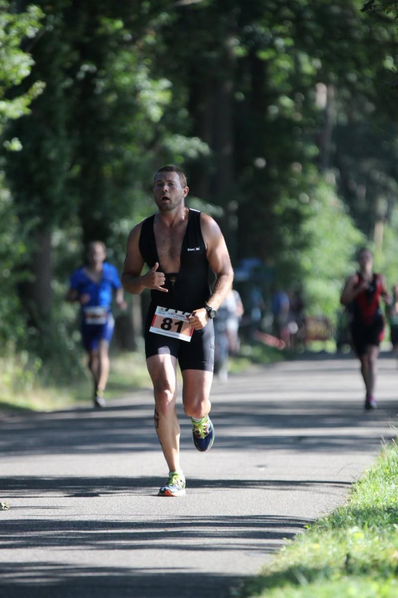 Een man rent een marathon op een pad.