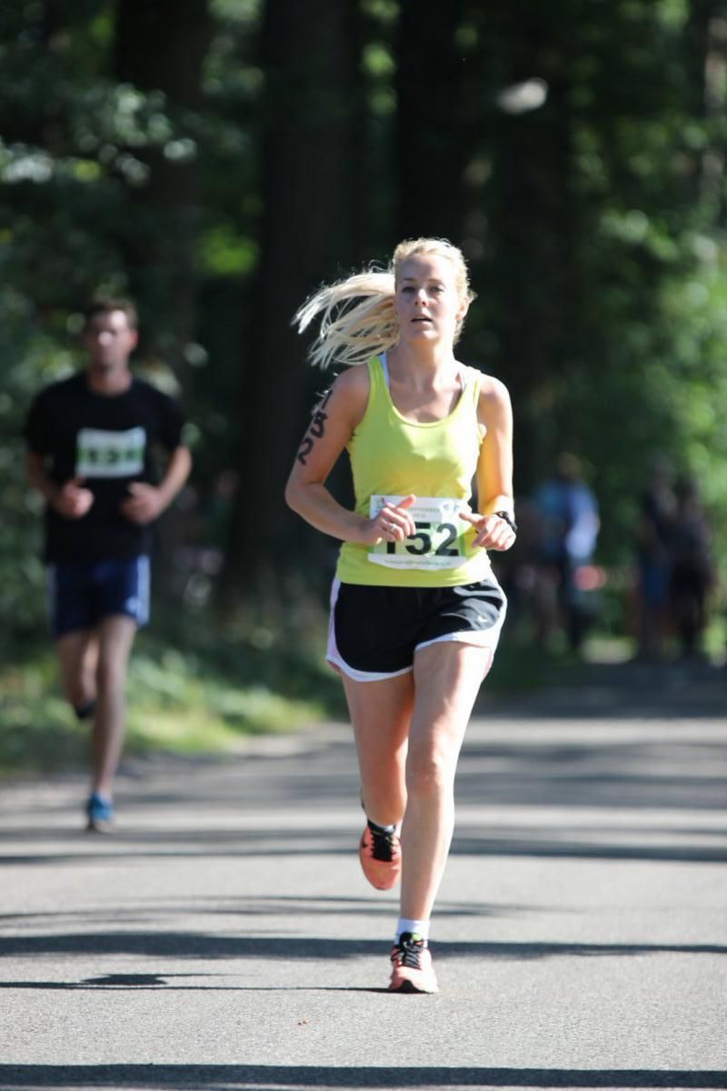 Een vrouw doet mee aan een race met nummer 152 op haar shirt.