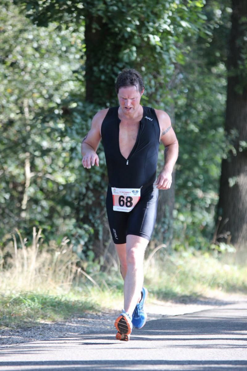 Een man rent over de weg tijdens een triatlon.