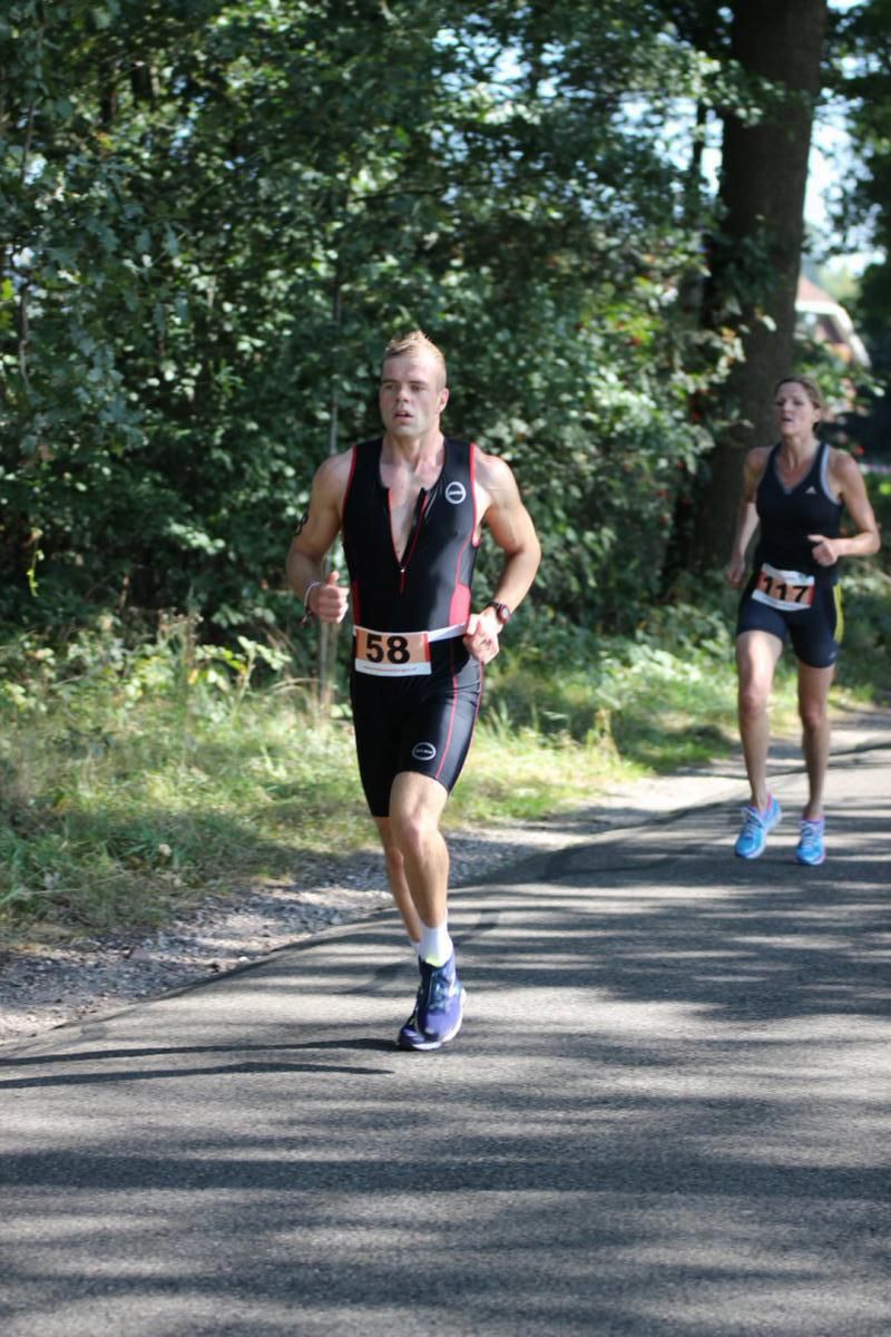Een man en een vrouw rennen over de weg.