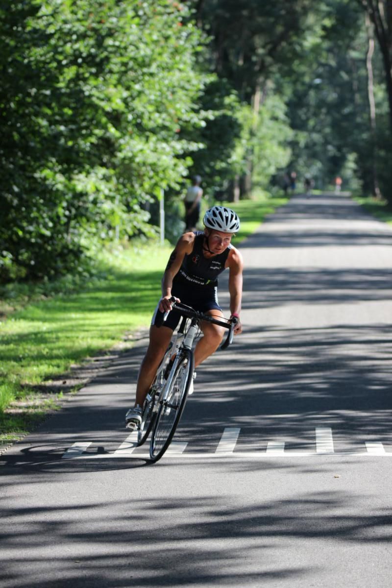 Een vrouw fietst over een weg.