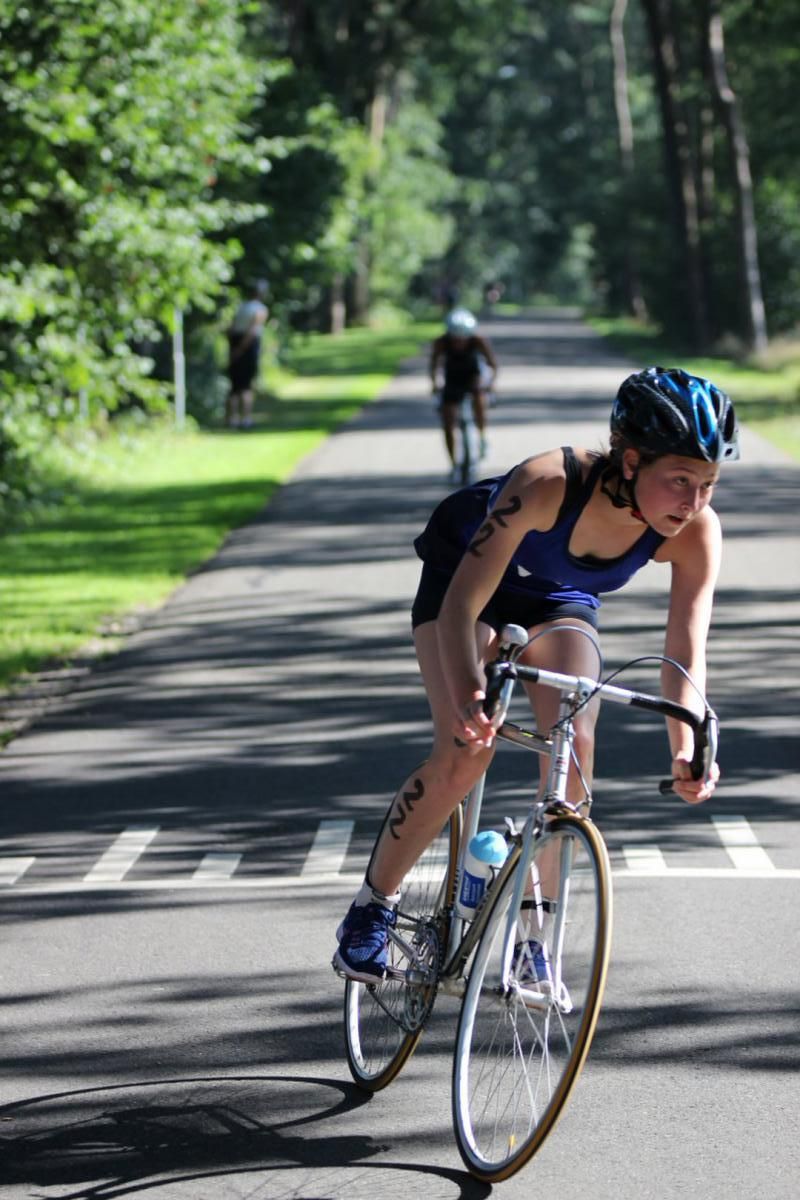 Een vrouw fietst over een weg.