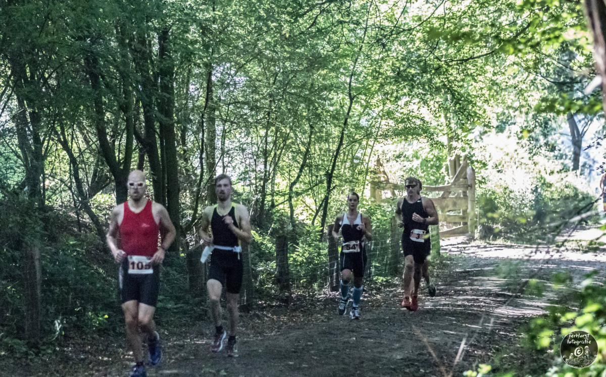 Een groep mensen rent door het bos.