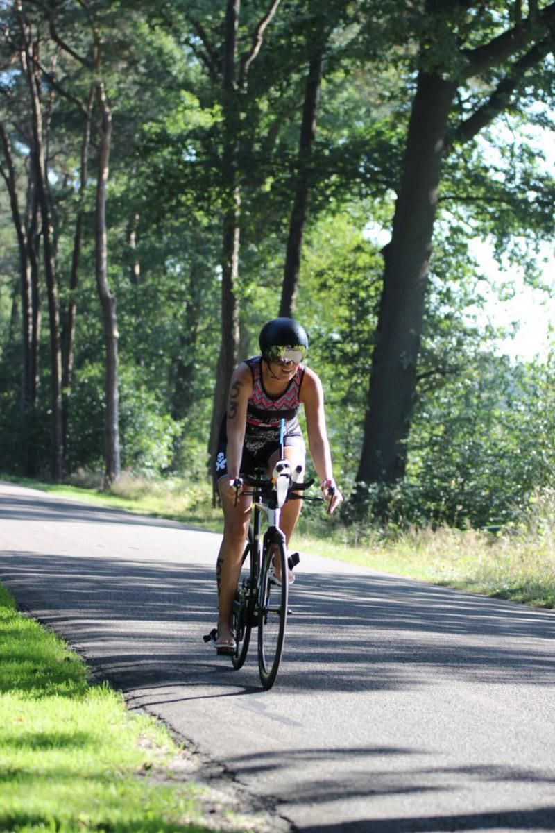 Een vrouw fietst over een weg.