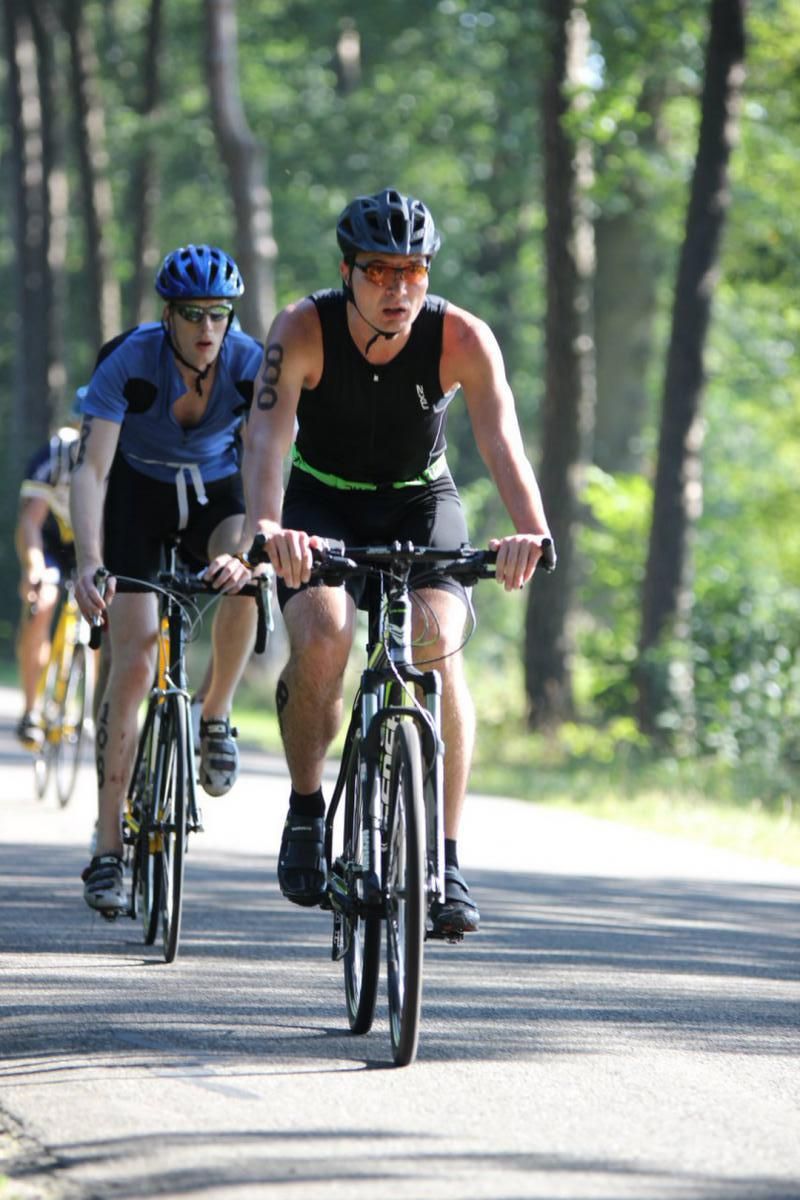 Een groep mensen fietst over een weg.