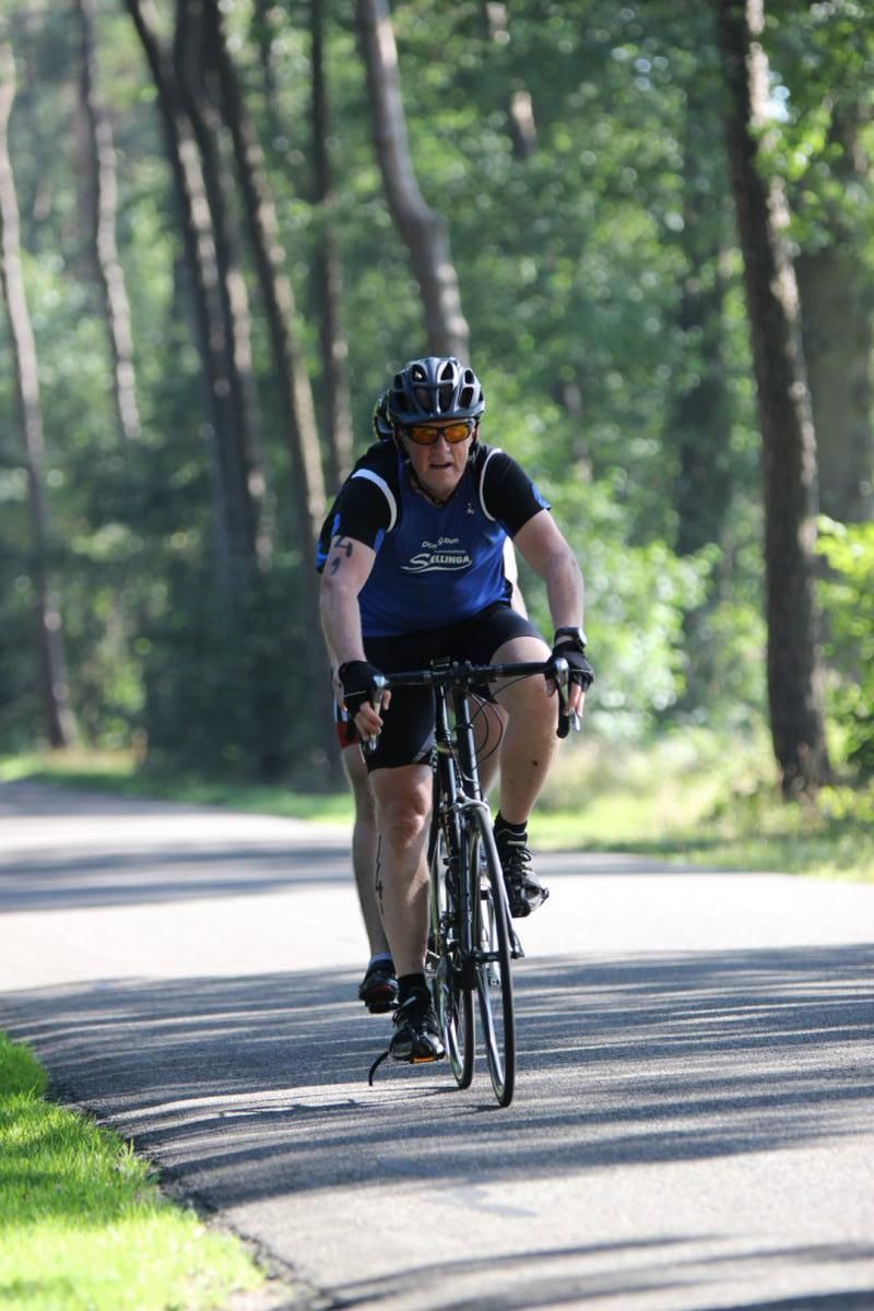 Een man en een vrouw fietsen over een weg.