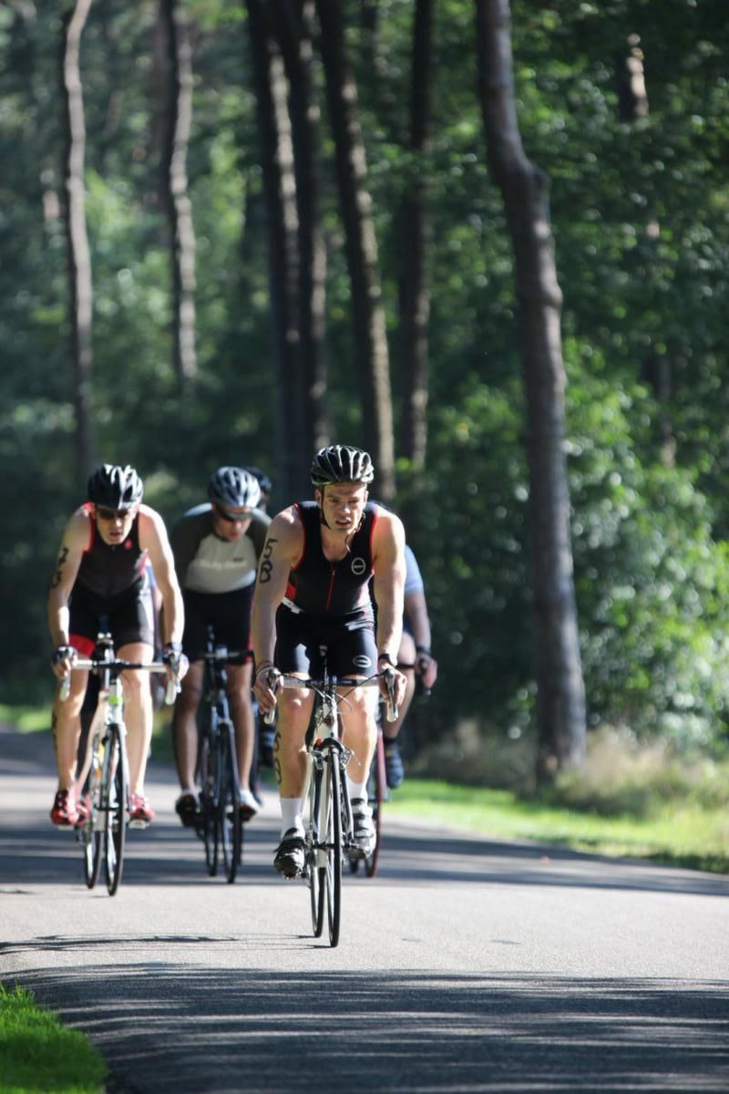 Een groep mensen fietst over een weg.
