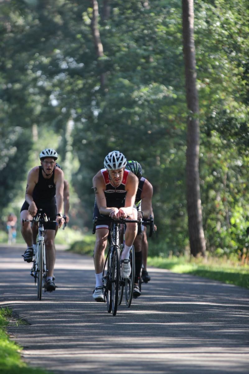 Een groep mensen fietst over een weg.