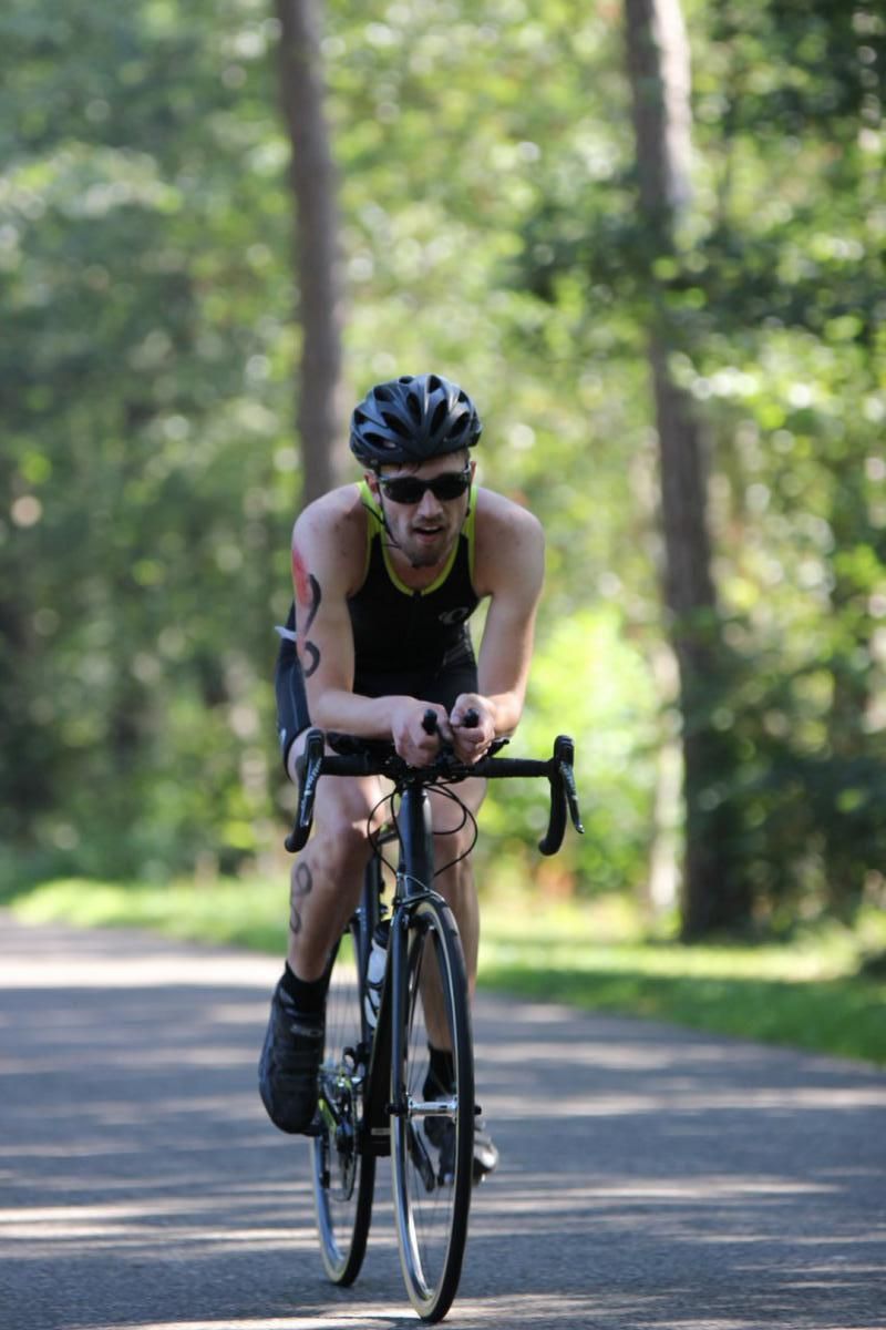 Een man fietst over een pad in het bos.