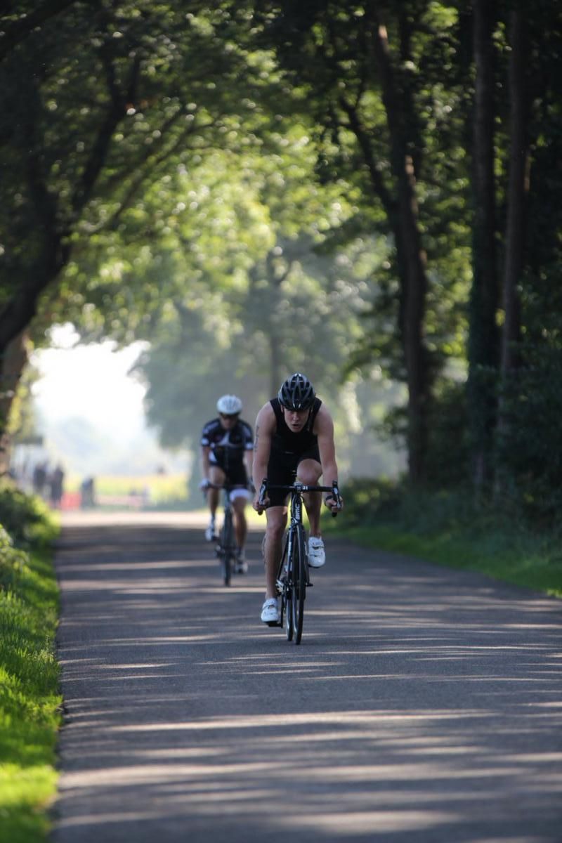 Twee mensen fietsen over een pad.