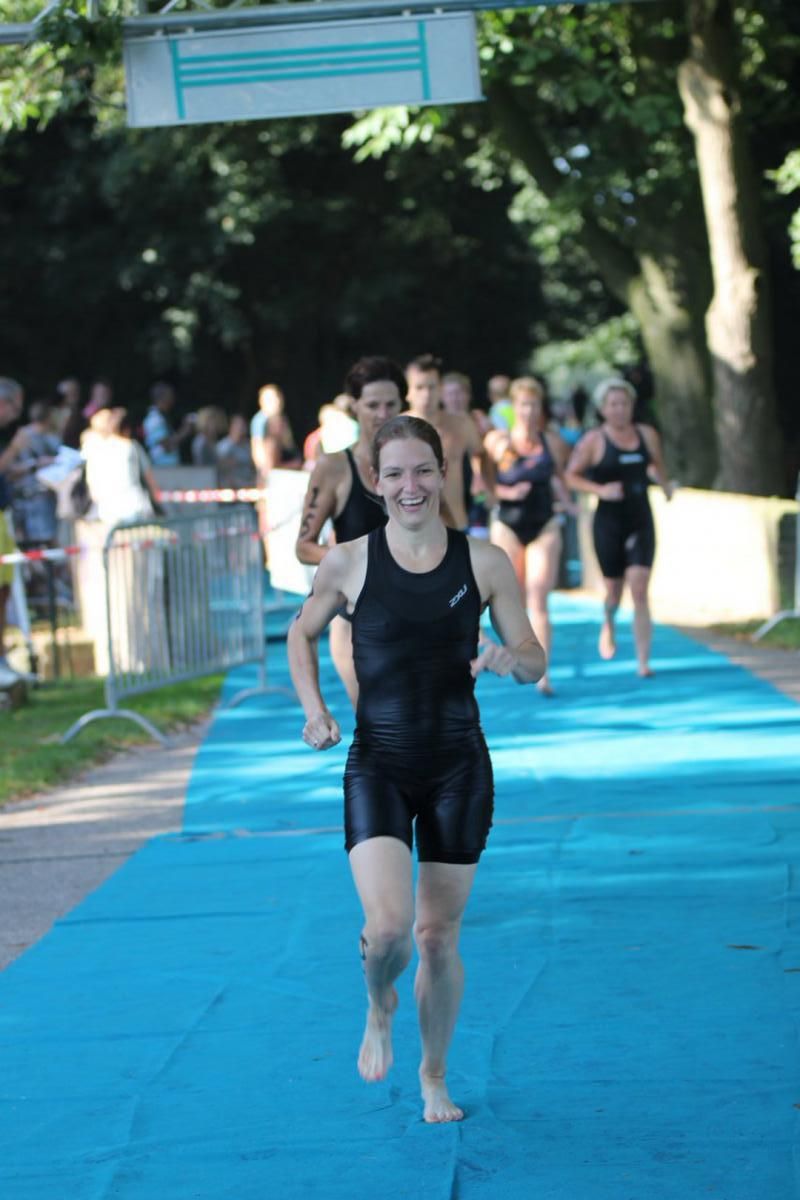 Een groep mensen rent op een blauwe mat.