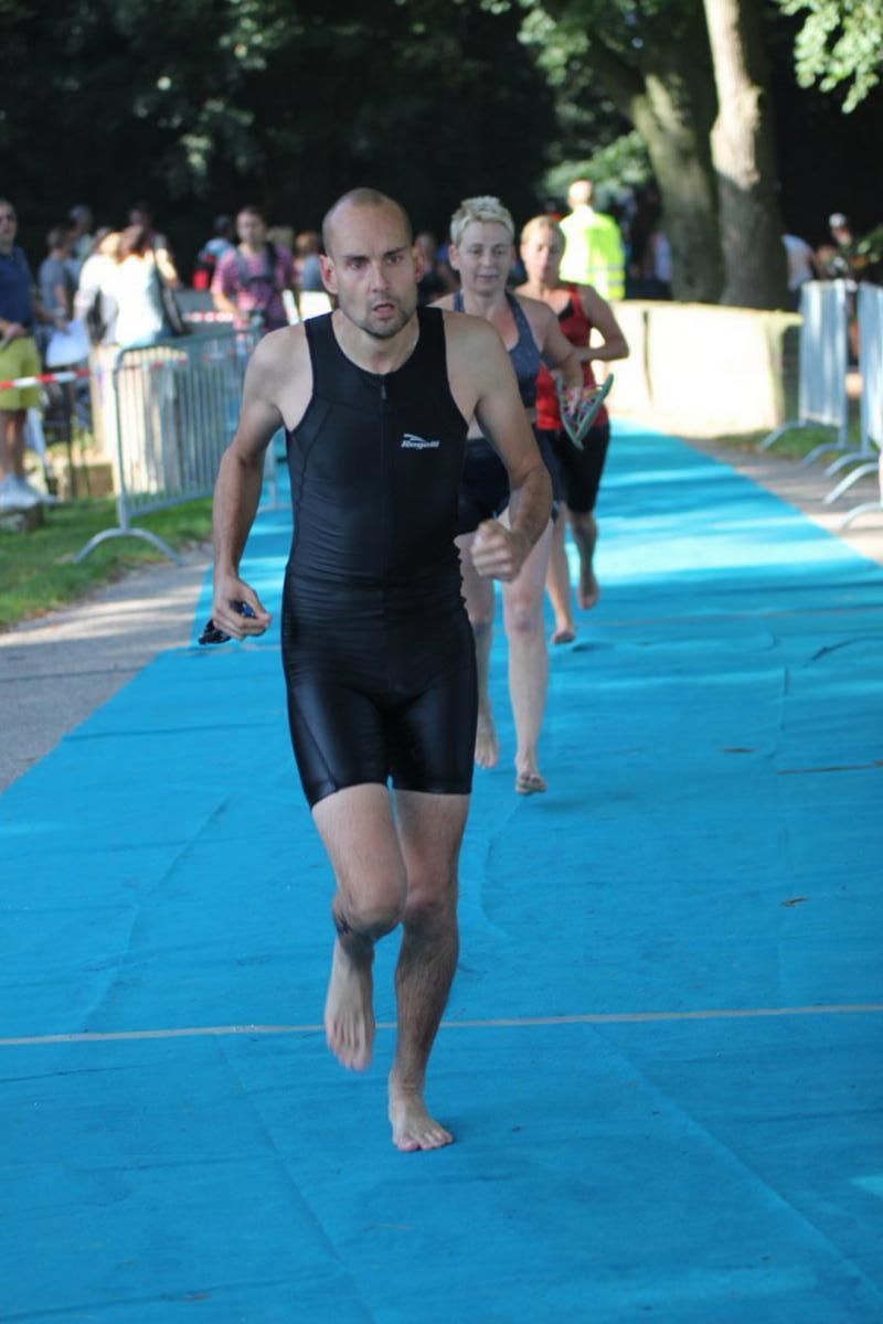 Een groep mensen rent op een blauwe mat