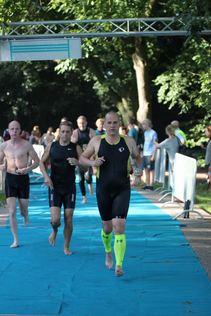 Een groep mannen rent op een blauwe mat