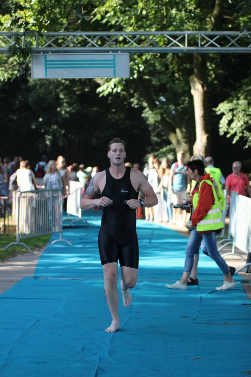 Een man in een wetsuit doet mee aan een triatlon.