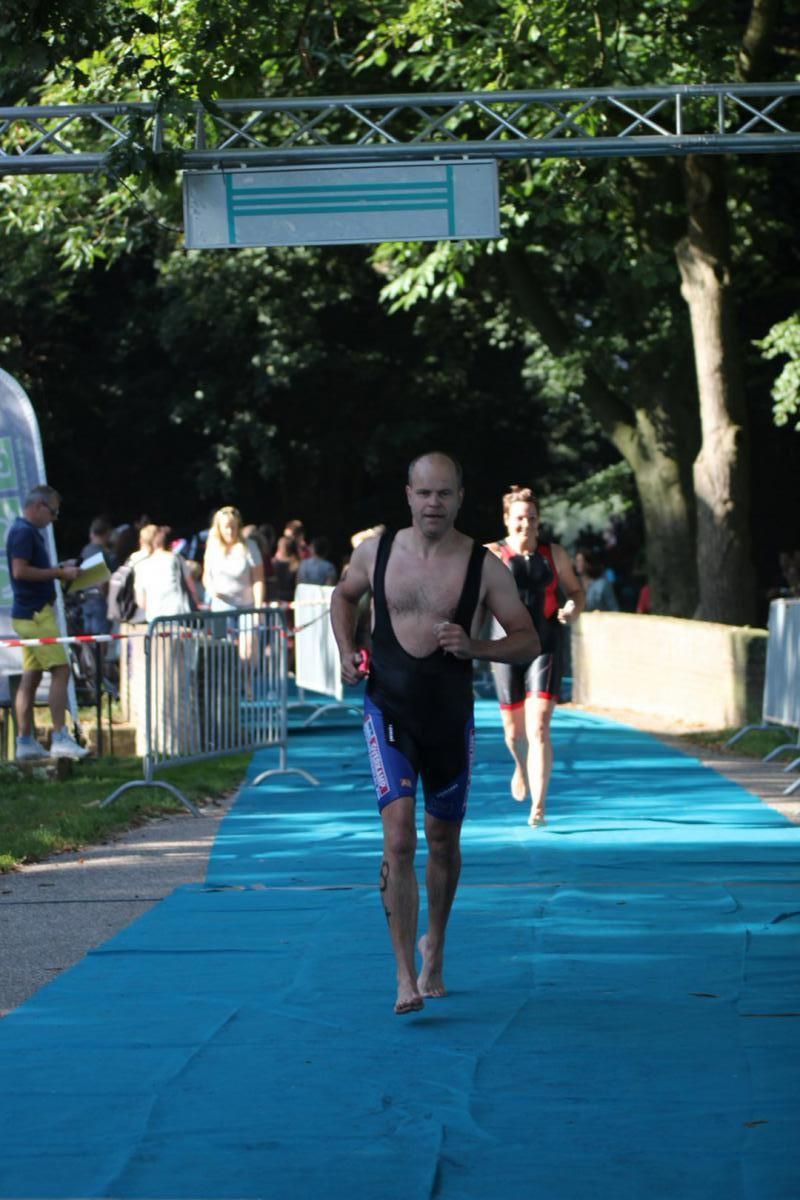 Een groep mensen rent over een blauwe loper.