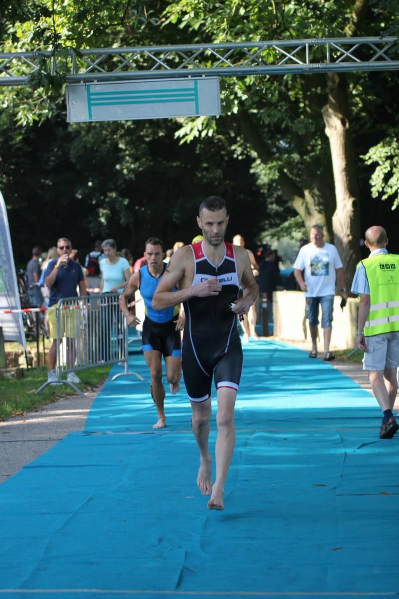 Een groep mensen rent over een blauwe loper.