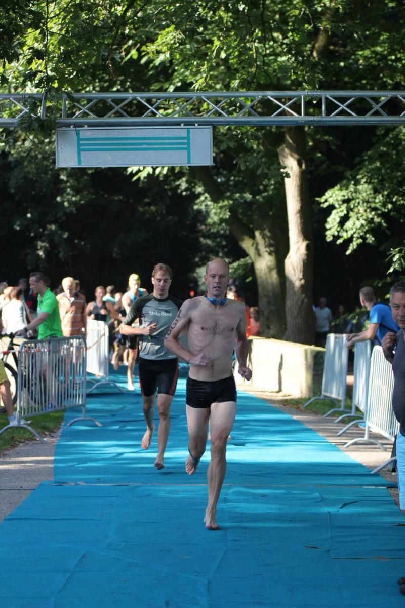 Een groep mensen rent over een blauwe loper.