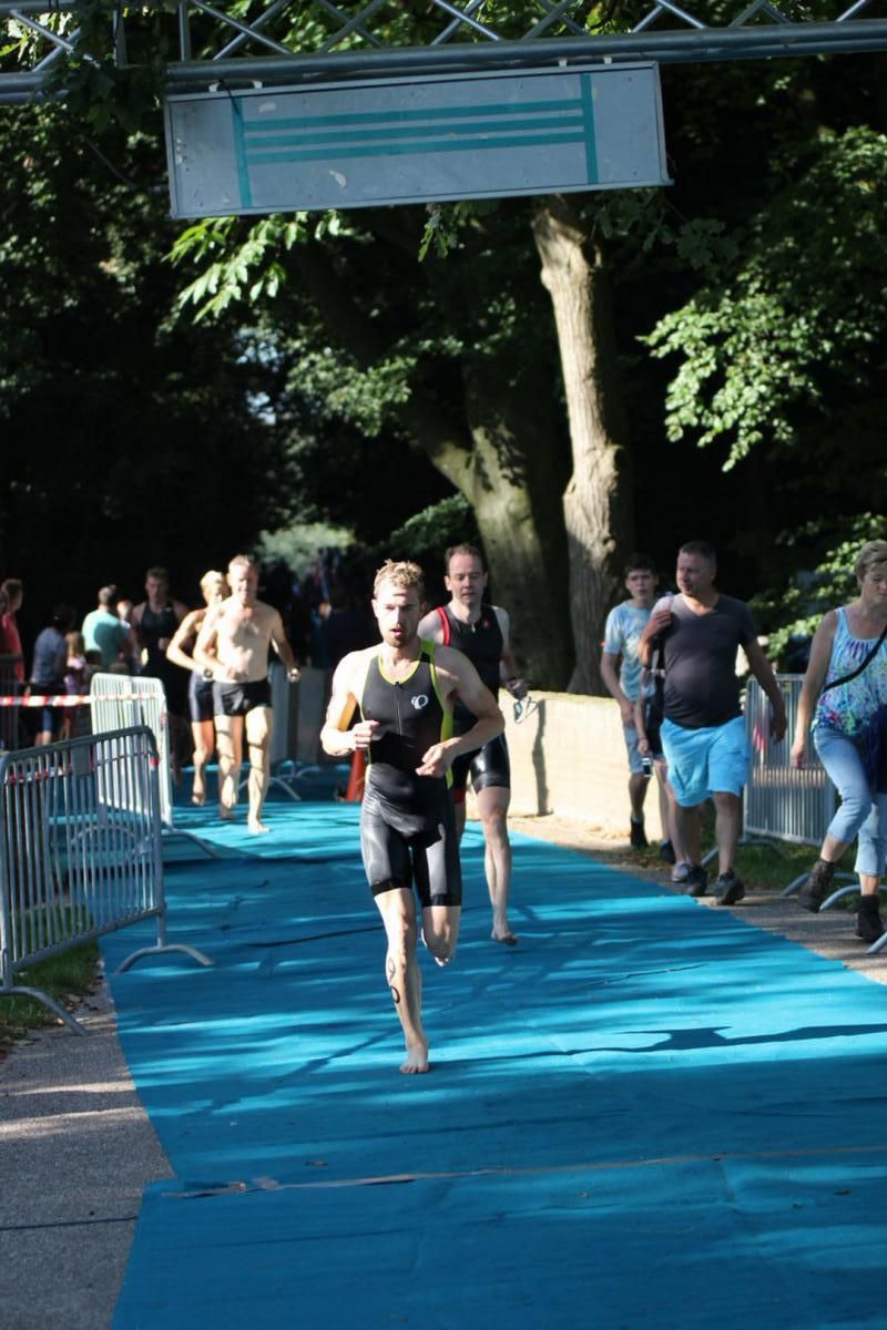 Een groep mensen rent over een blauwe loper.