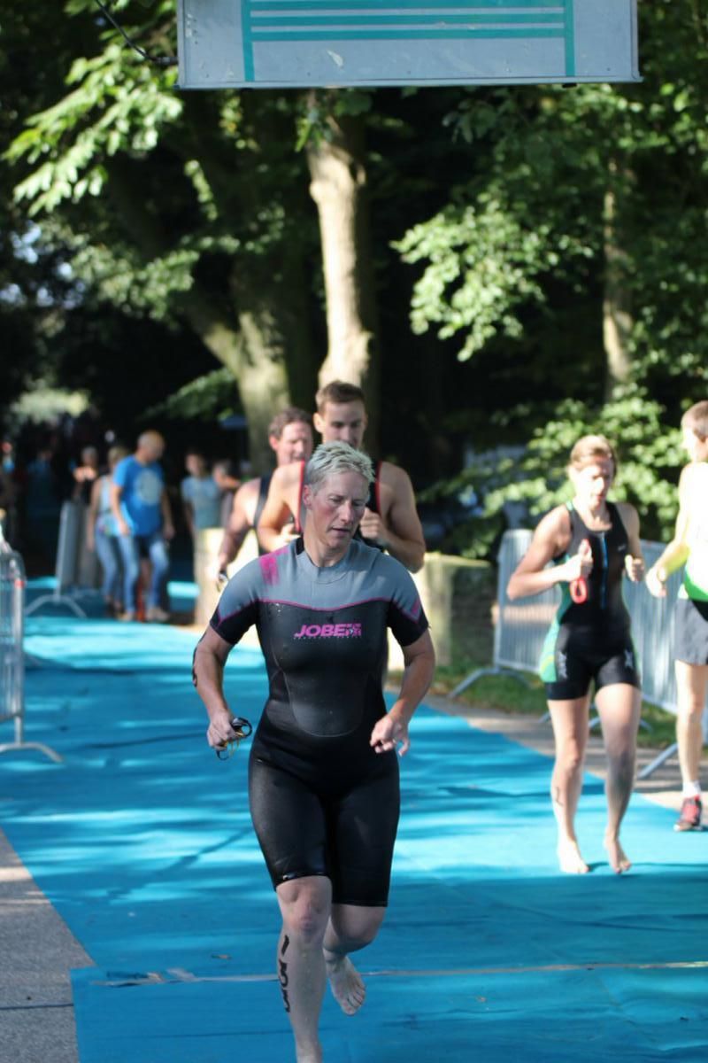 Een vrouw in een wetsuit doet mee aan een race