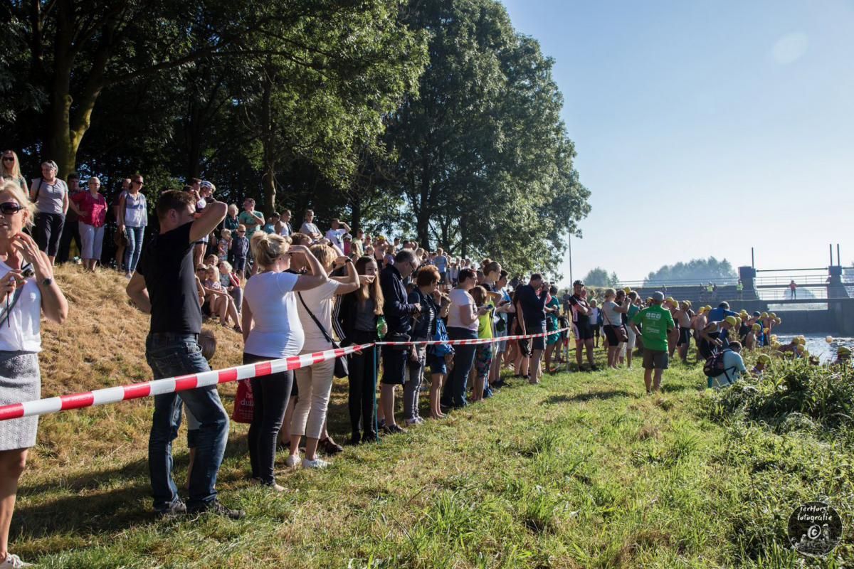 Een grote groep mensen staat in een grasveld.