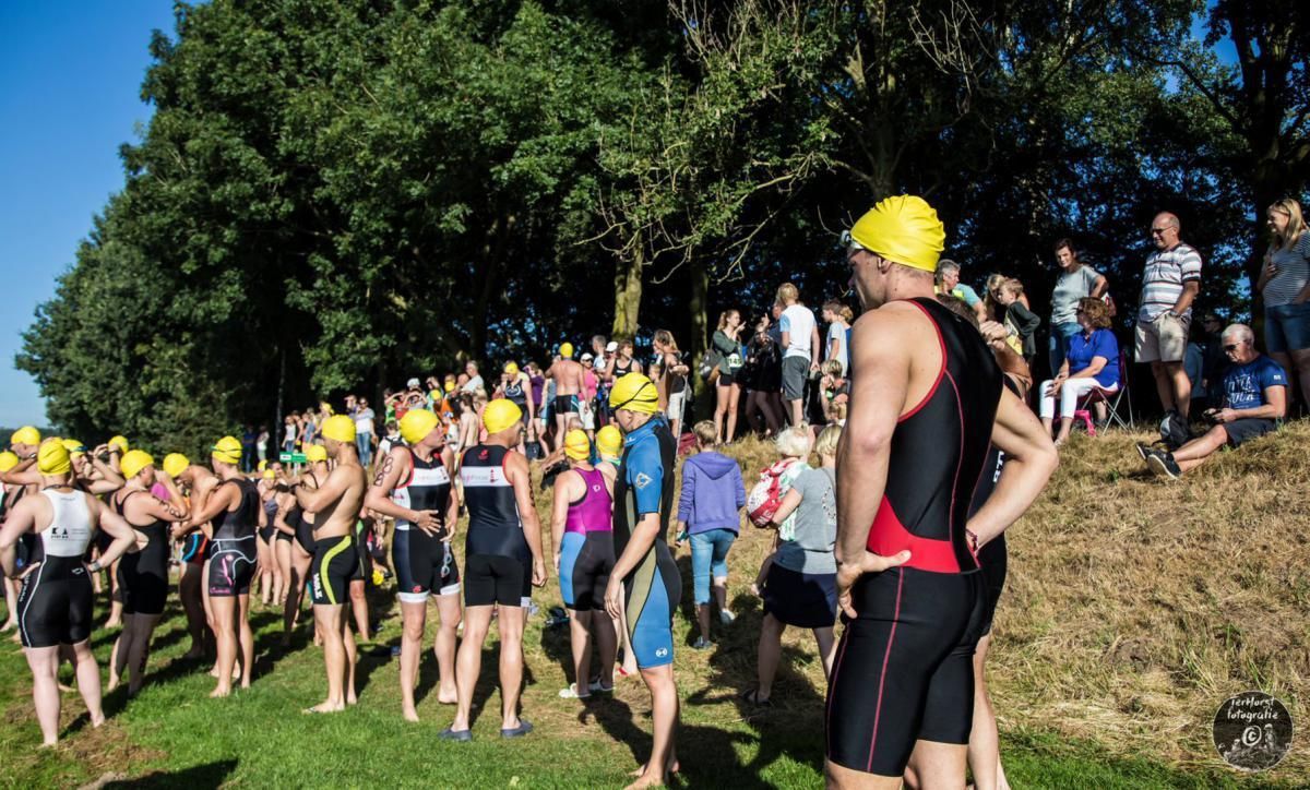 Een groep mensen staat in een veld met badmutsen op.
