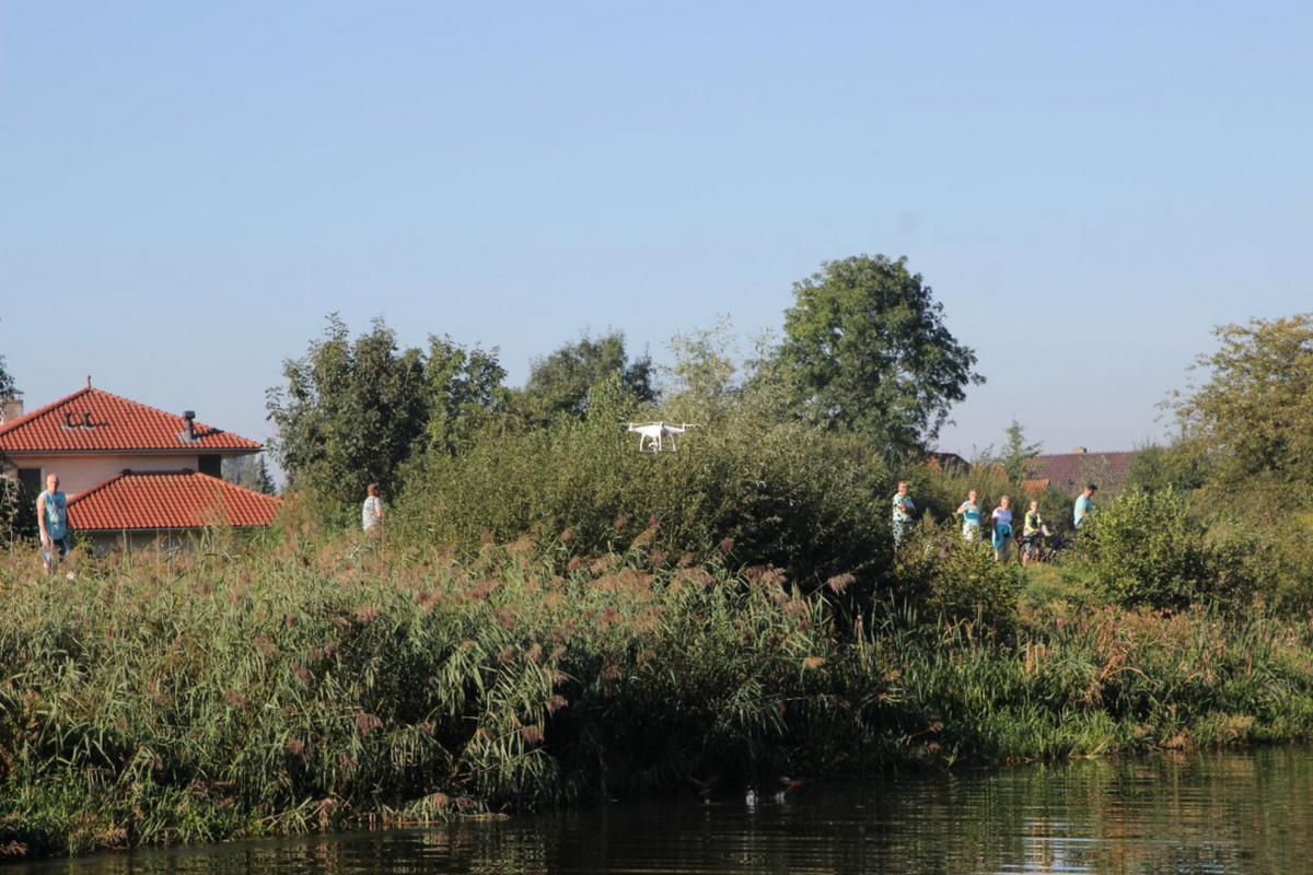 Een groep mensen staat op een heuvel naast een watermassa.