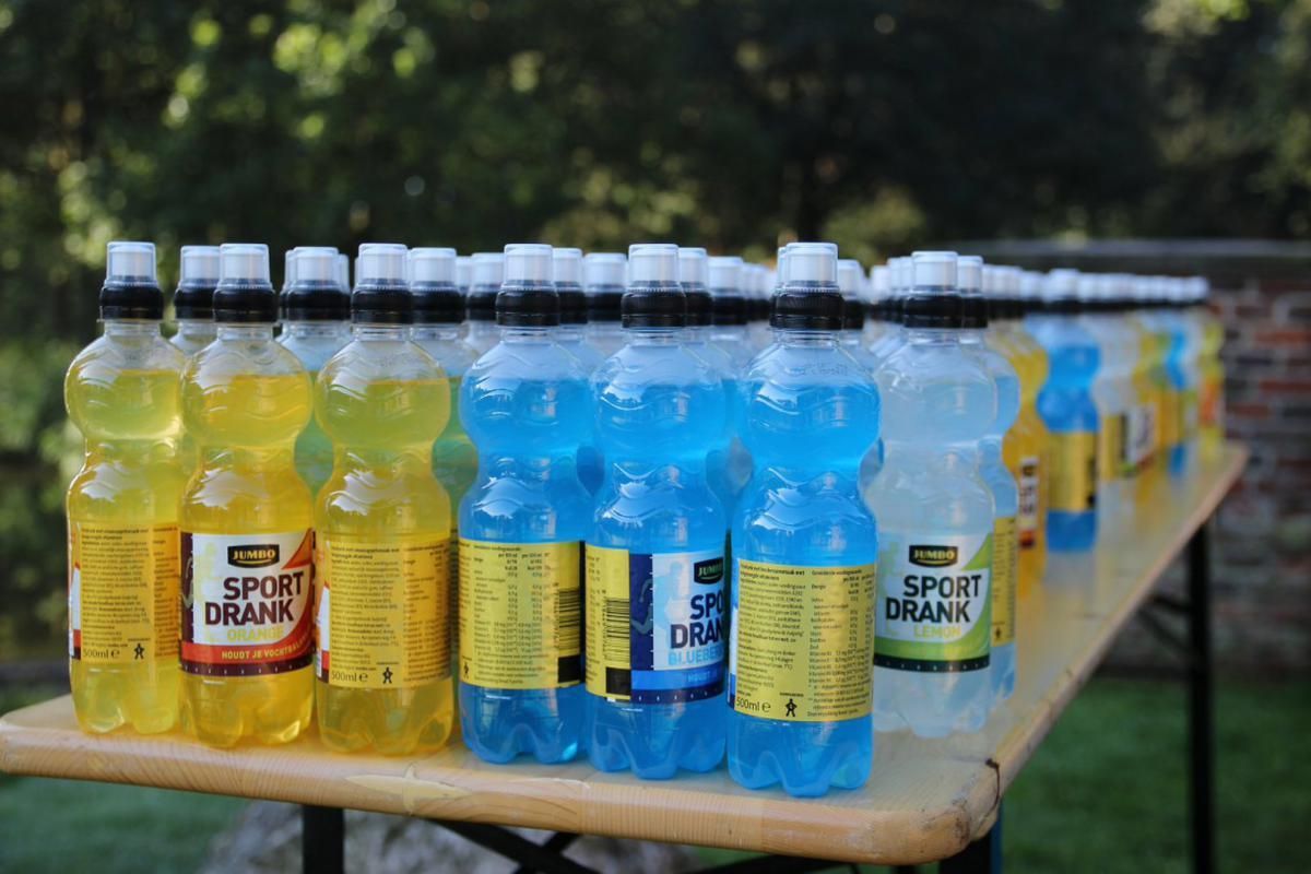 Op een tafel staan ​​een aantal flessen sportdrankjes op een rij.
