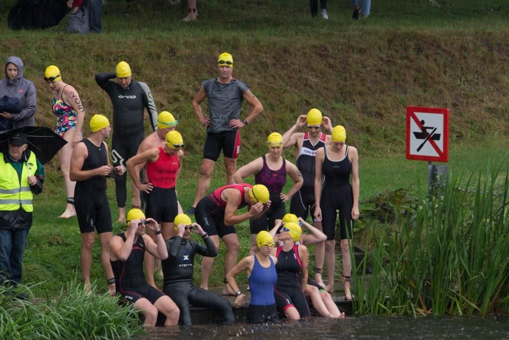 Een groep mensen maakt zich klaar om in een meer te gaan zwemmen.