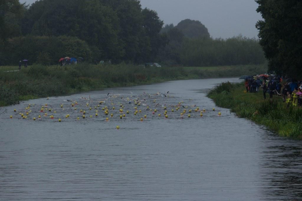 Een groep mensen staat aan de oever van een rivier