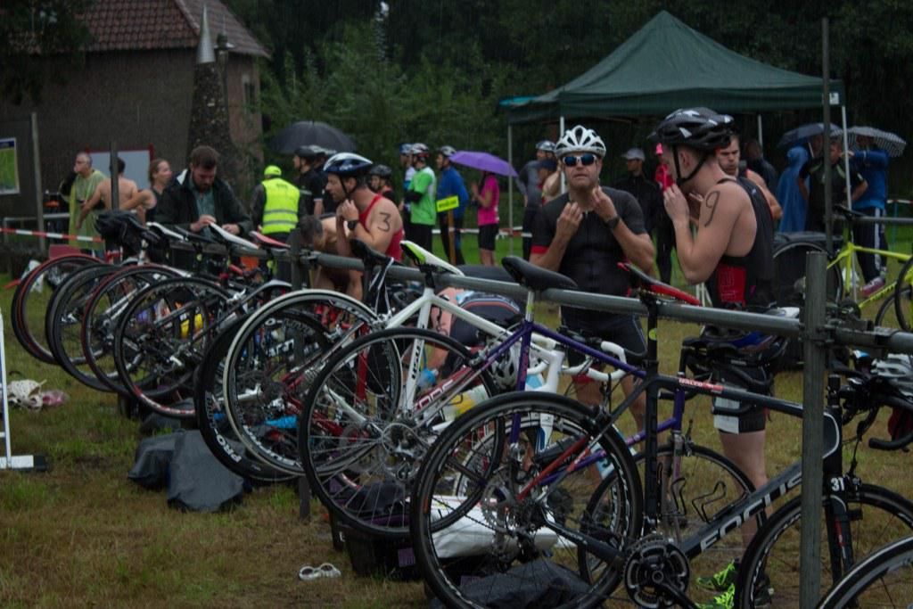 Een groep mensen staat rond een rij fietsen.