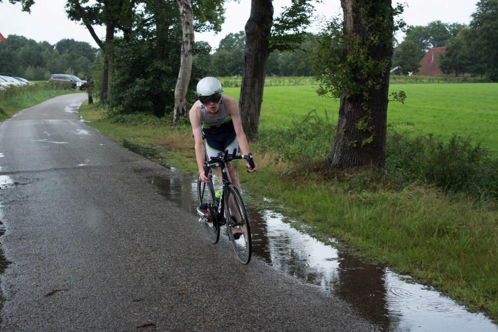 Iemand fietst over een natte weg
