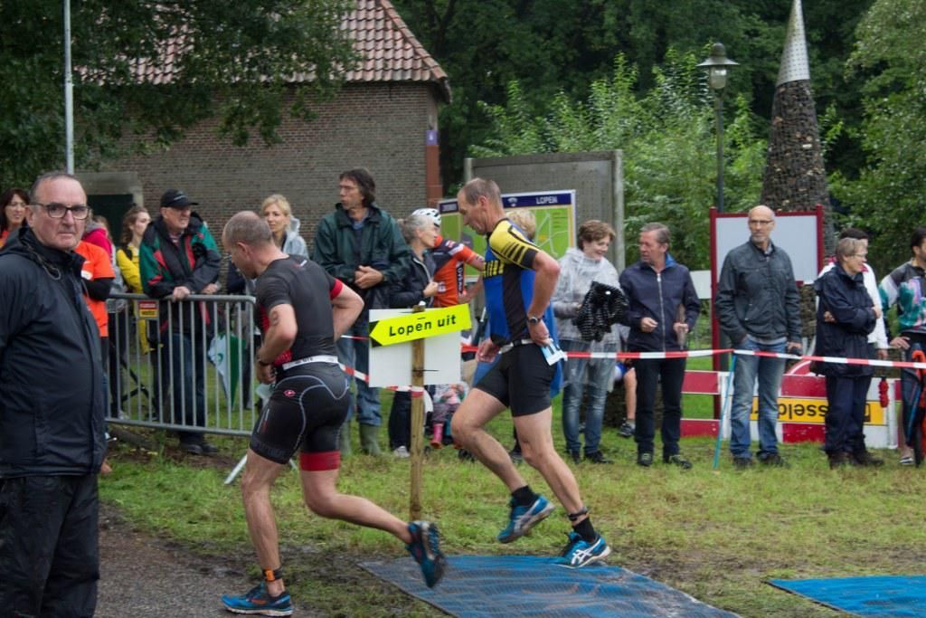 Een groep mannen rent een marathon voor een publiek.