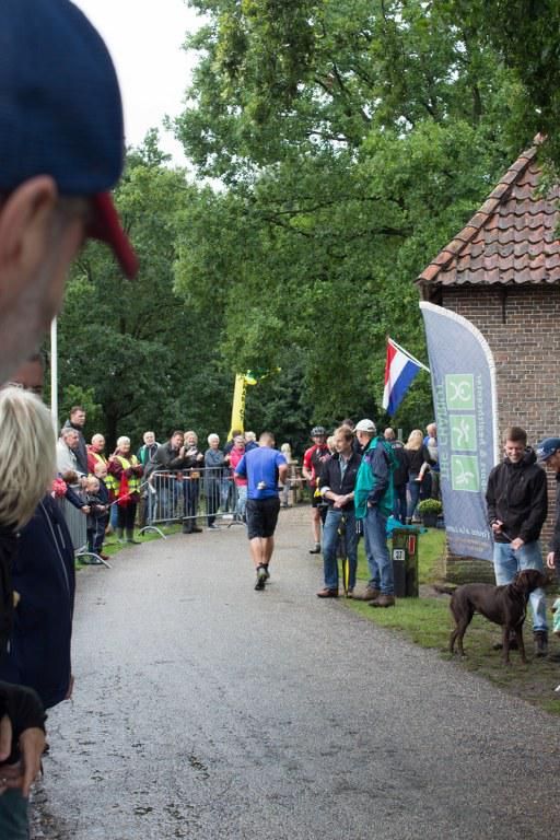 Een groep mensen verzamelt zich langs de kant van de weg