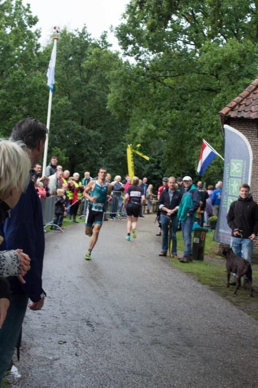 Een groep mensen kijkt naar een hardloper in een race