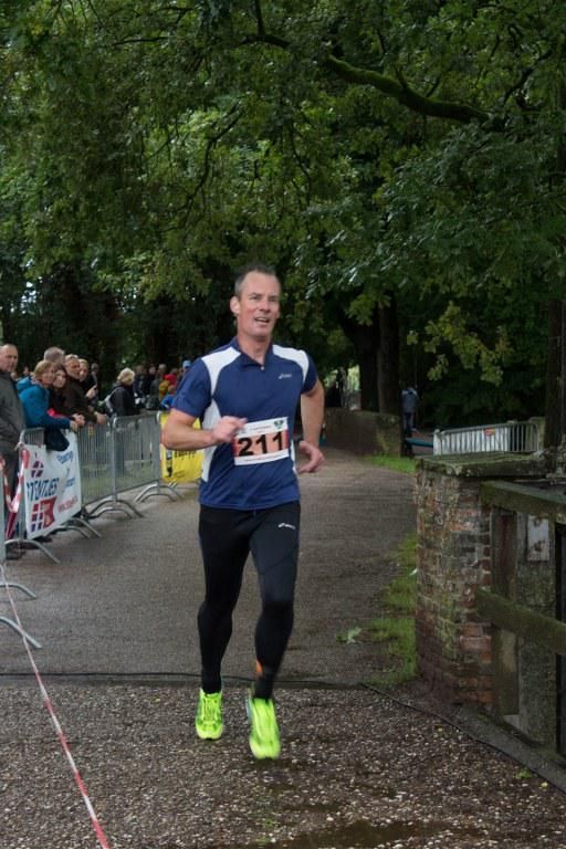 Een man doet mee aan een race met nummer 211 op zijn shirt.