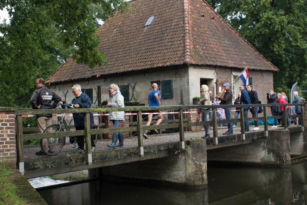 Een groep mensen loopt over een brug over een rivier.