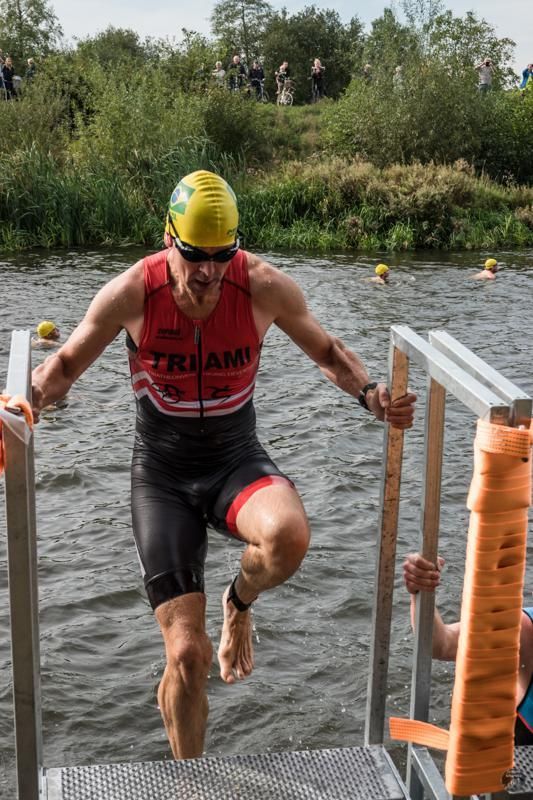 Een triatlonatleet komt uit het water.
