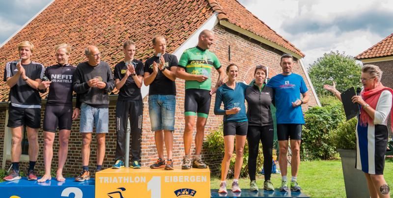 Een groep mensen die op een podium staat.