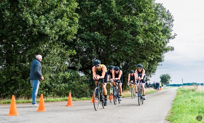 Een groep mensen fietst over een weg.