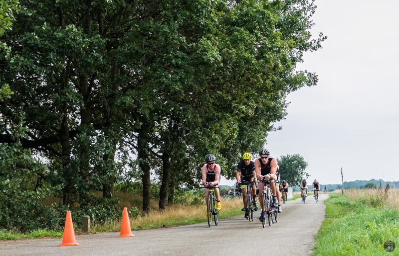 Een groep mensen fietst over een weg.