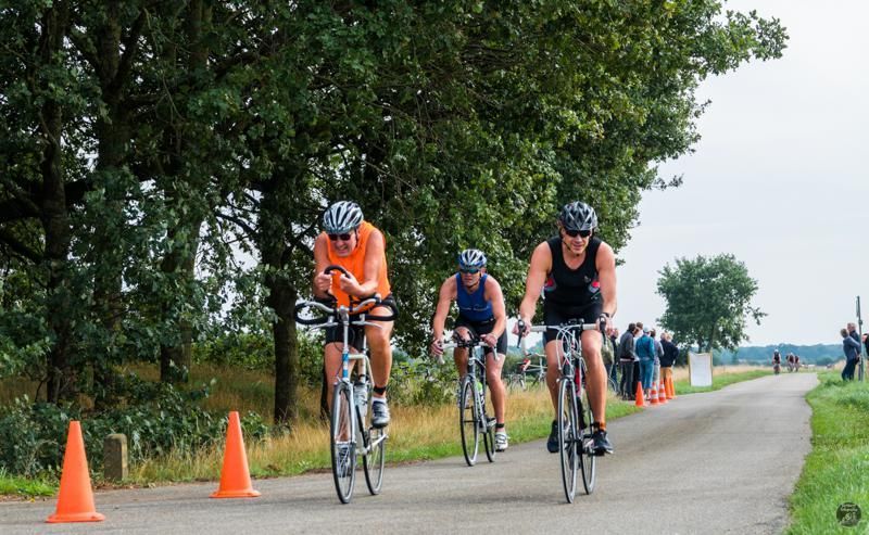 Een groep mensen fietst over een weg.