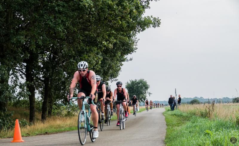 Een groep mensen fietst over een pad.