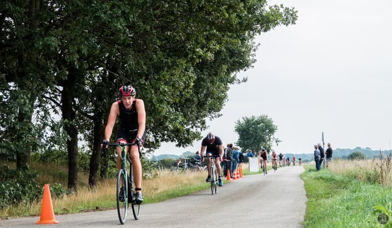 Een groep mensen fietst over een weg.