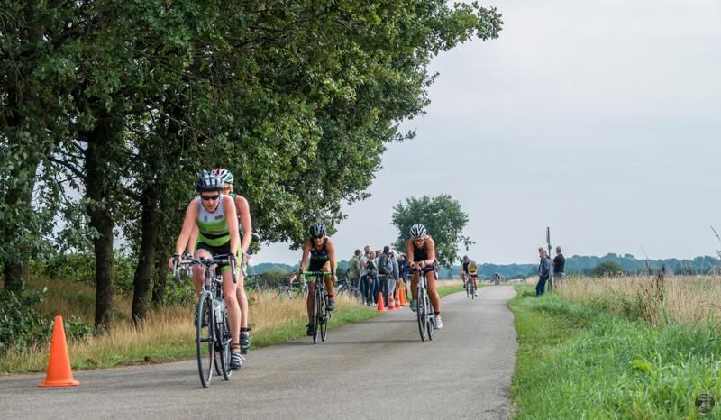 Een groep mensen fietst over een weg.
