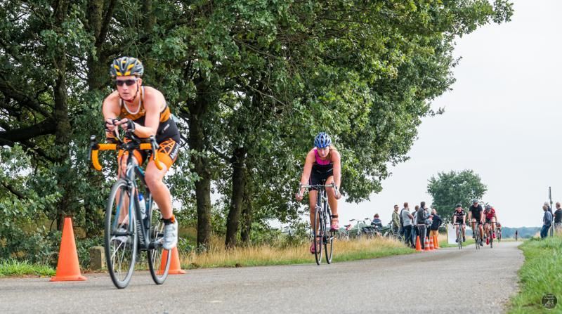 Een groep mensen fietst over een weg.