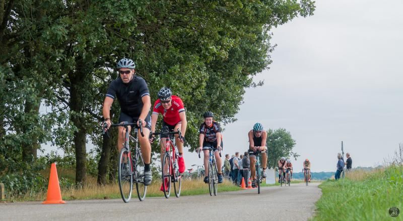 Een groep mensen fietst over een weg.