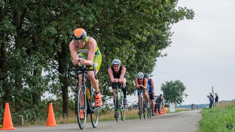 Een groep mensen fietst over een weg.