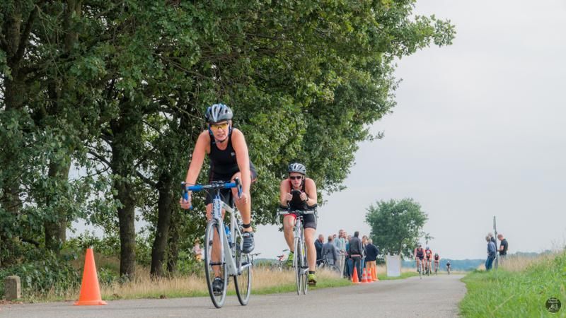 Een groep mensen fietst over een weg.