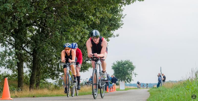 Een groep mensen fietst over een weg.