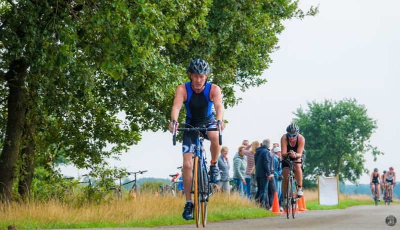 Een groep mensen fietst over een weg.